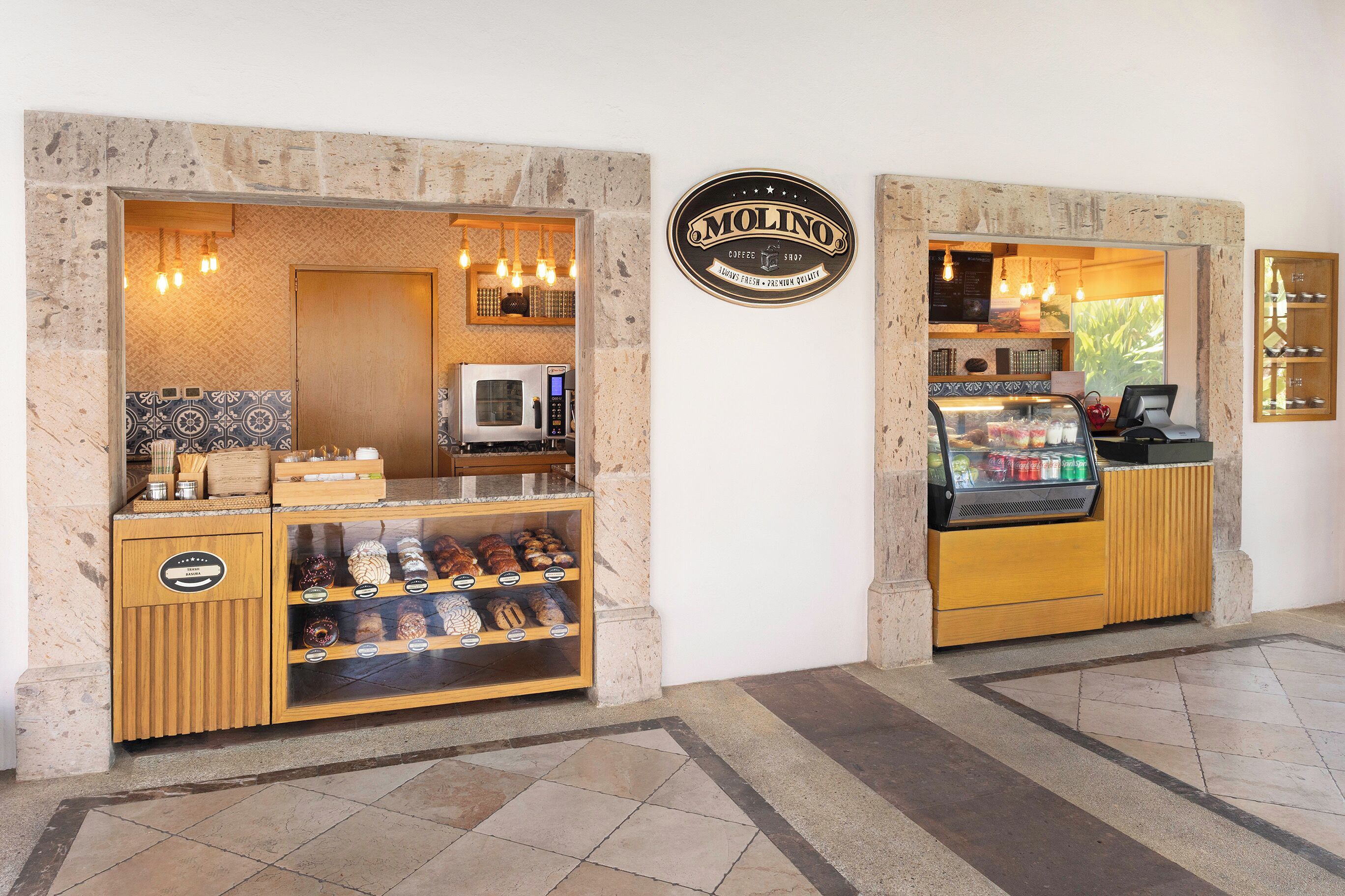 Un café où l’on peut admirer une vitrine remplie de pâtisseries et où se trouve une machine à café.