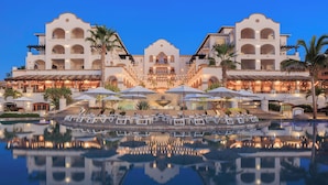A hotel with a central courtyard, a pool, and outdoor seating areas.