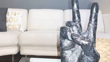 A white sofa with a cushion that has "MY GOD ISCKY" printed on it.