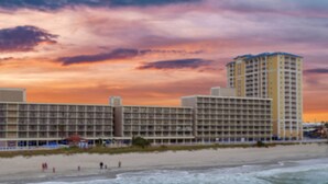 A hotel with multiple floors and balconies, located near a beach with a sunset in the background. - Westgate Myrtle Beach Oceanfront 828-94 (Myrtle Beach)