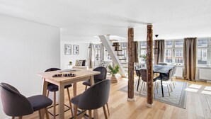 Un espace de vie moderne comprenant un coin repas, un escalier et de grandes fenêtres.