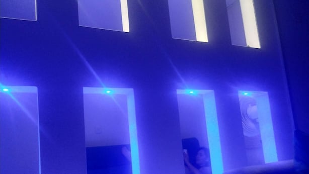 Une pièce dotée de plusieurs fenêtres rectangulaires, chacune étant éclairée par une lumière bleue.