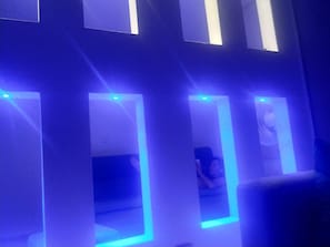A room with multiple rectangular windows, each illuminated by blue light. - Total Spacio Relax in Cundinamarca (Tocaima)