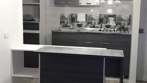 Une cuisine moderne dotée d’un îlot central, de meubles encastrés et de luminaires suspendus.