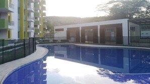 Une piscine entourée de bâtiments modernes dotés de balcons.