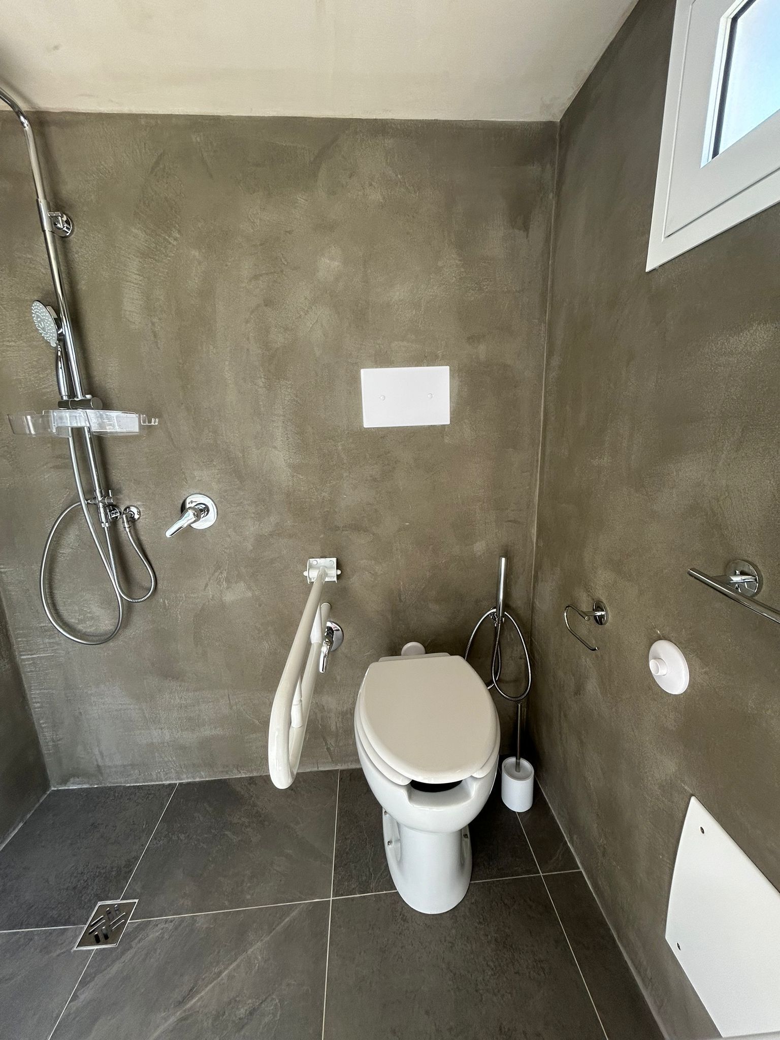 Un baño con inodoro, ducha y lavabo.