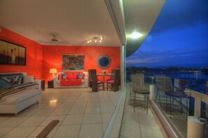 Relax in this stylish living room with a sofa, round coffee table, and city views from the balcony.