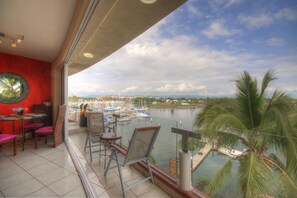 Enjoy the serene marina views from this balcony with a table and chairs.
