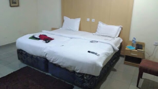 Ein Standardzimmer mit Bett, Nachttisch und Stuhl.