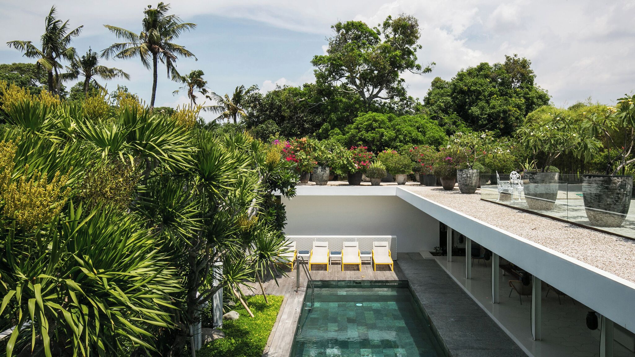 Una piscina al aire libre, sombrillas, tumbonas