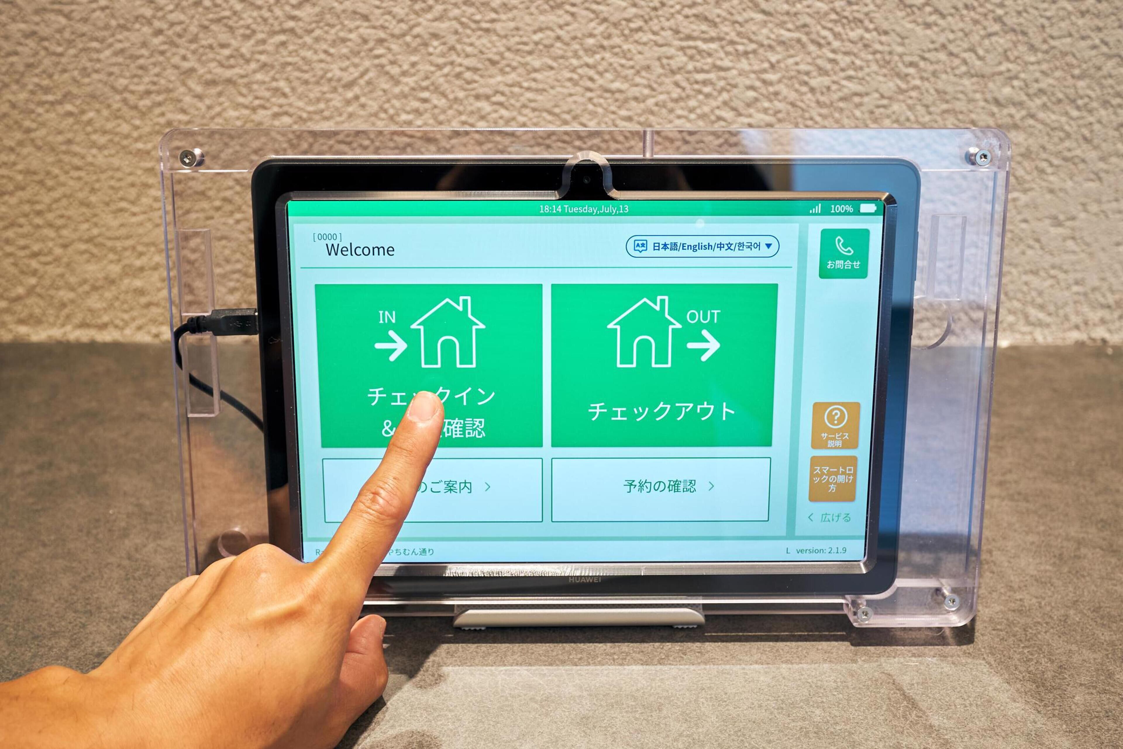 A tablet displaying a welcome screen with options for entering or exiting a building, and buttons for checking in and out.
