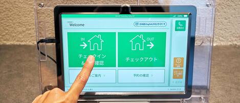 A tablet displaying a welcome screen with options for entering or exiting a building, and buttons for checking in and out.