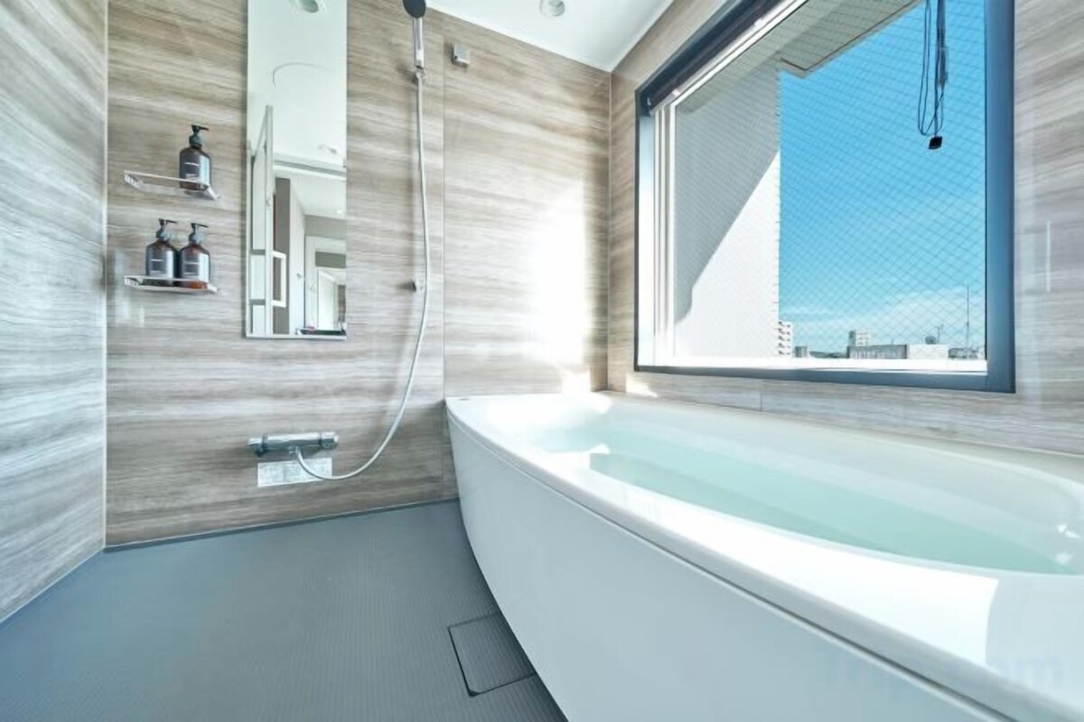 Een aparte badkuip en douche, een haardroger, een bidet, handdoeken