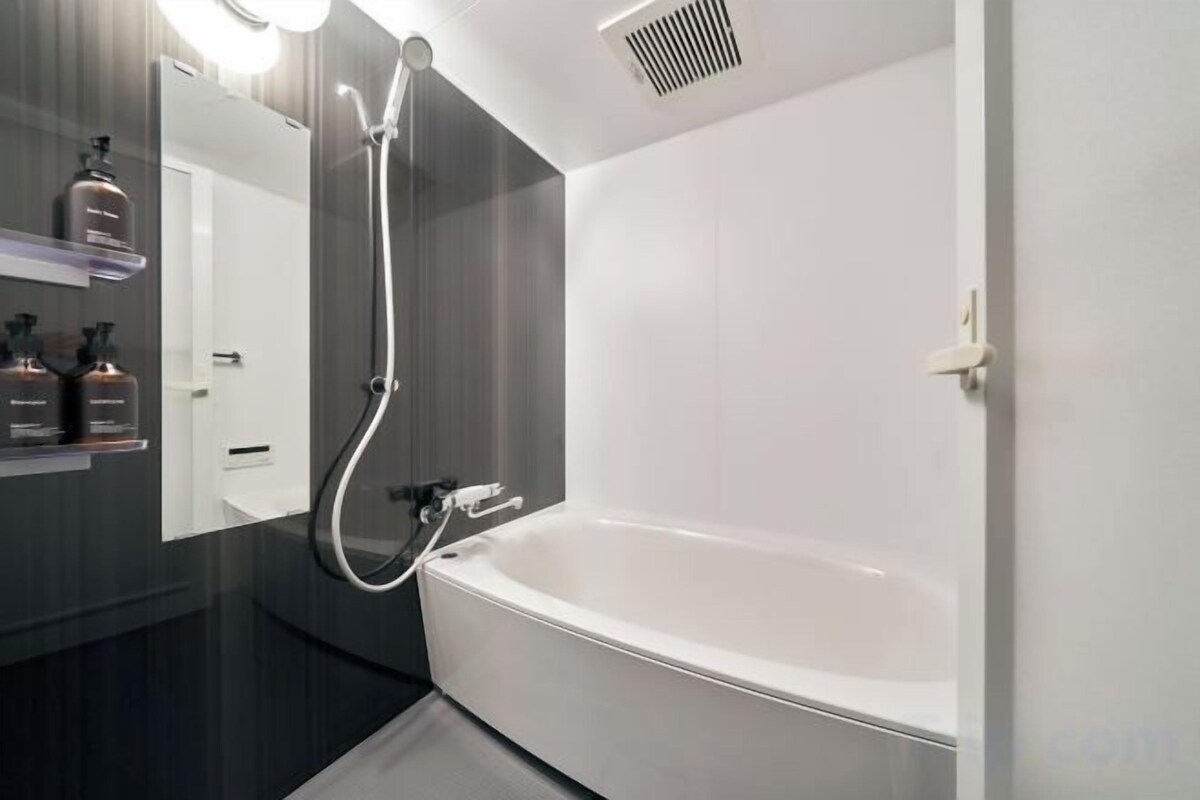 Een aparte badkuip en douche, een haardroger, een bidet, handdoeken