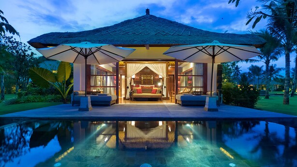 A luxurious villa with a large pool, a thatched-roof structure, and a well-lit interior. - Kaba Kaba Estate (Cepaka)