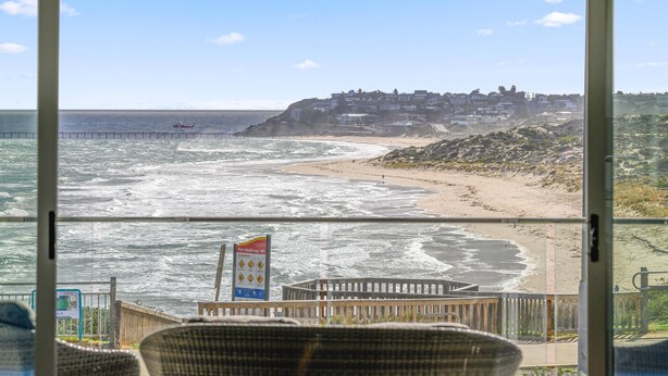 A view of a beach from a balcony with a sign indicating Port Neighbora St.