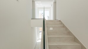Una escalera moderna con barandillas de cristal y un diseño minimalista.