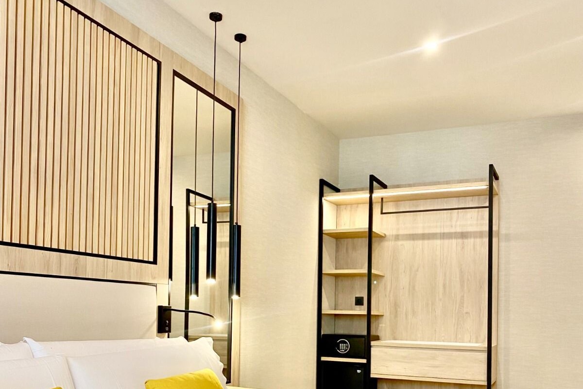Un dormitorio moderno con una cama grande, un armario y un espejo.