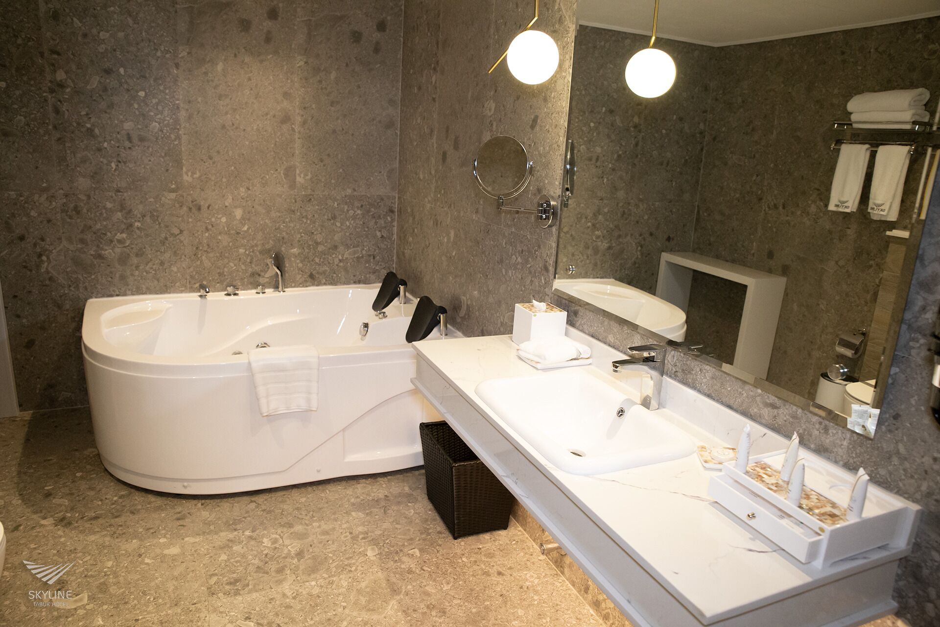 A modern bathroom with a large freestanding bathtub, a double sink vanity, and a mirror above the sink.