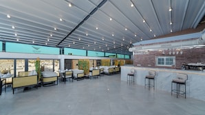 Un espacio interior amplio con techos altos, asientos modernos y una zona de bar.