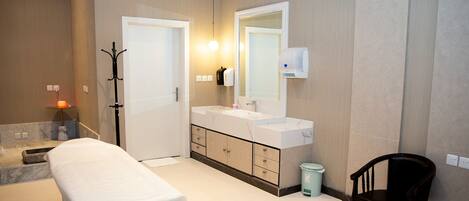 A modern bathroom with a double sink vanity, a mirror, a towel rack, and a trash bin.
