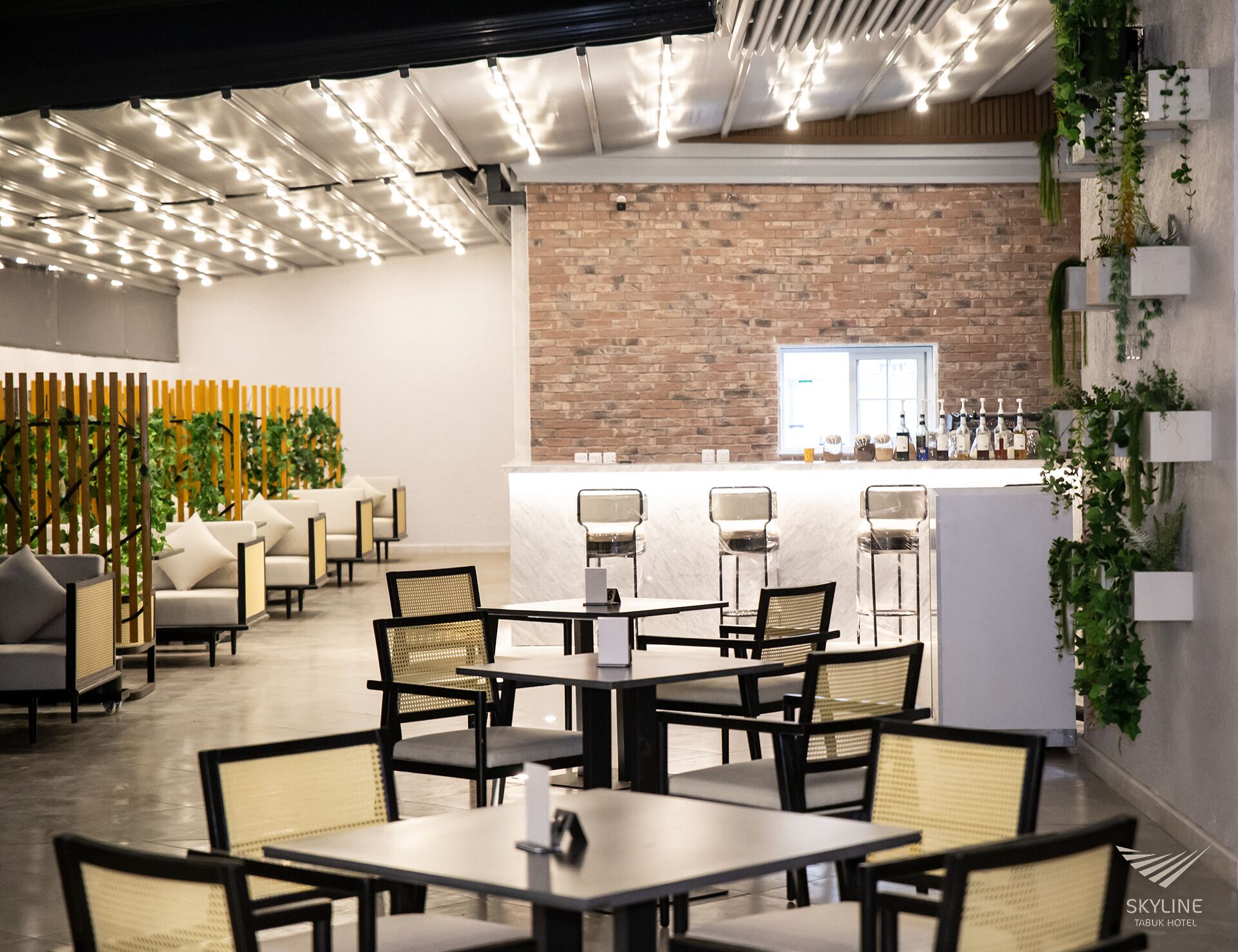 A modern dining area with a brick wall, bar, and seating.