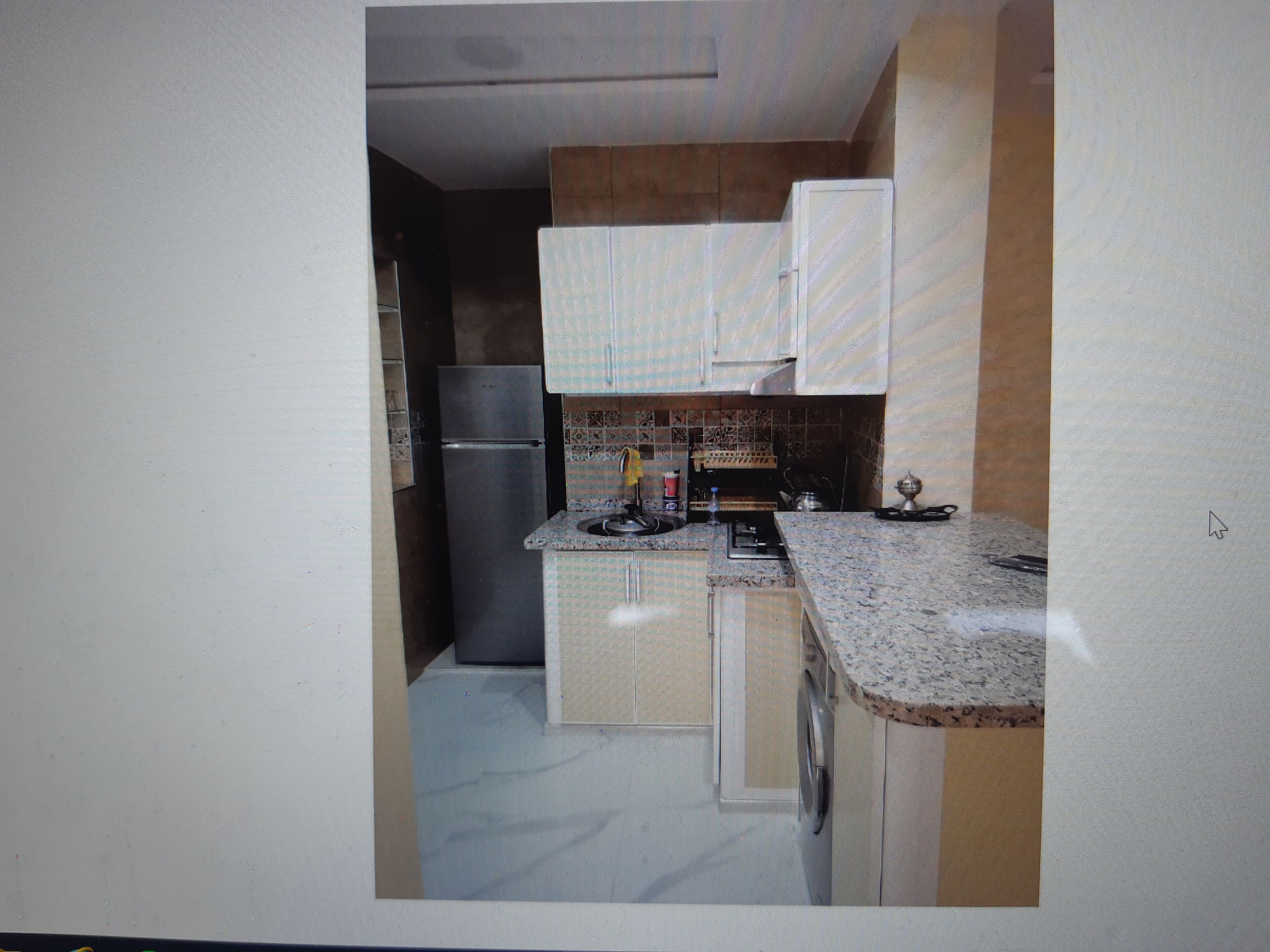 A compact kitchen with a refrigerator, a sink, and a stove.
