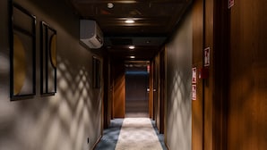 A hallway with wooden doors, a patterned carpet, and wall-mounted air conditioning units. - RentPlanet - Apartamenty Gwarna (Wroclaw)