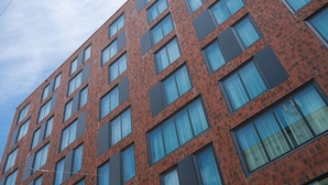 A multi-story building with a brick facade and numerous windows. - RentPlanet - Apartamenty Gwarna (Wroclaw)