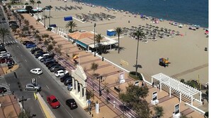 A coastal cityscape with a beach, parking areas, and a clear sky. - Beautiful villa with private pool and garden (Mijas)