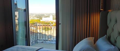 Tweepersoonskamer, balkon | Een minibar, een bureau, beddengoed