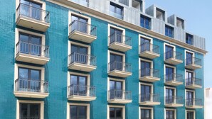 A multi-story building with a blue-tiled facade and balconies.