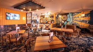 A restaurant with wooden tables and chairs, a bar area, and a mural on the wall. - St Osyth- Sleeps8-freeparking-wifi-holidaypark (Clacton-on-Sea)