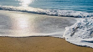 A beach with waves gently lapping onto the shore.