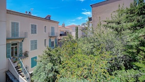 Une rue étroite, bordée de bâtiments des deux côtés, avec des balcons et un escalier.