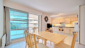 A modern apartment with a dining area, kitchen, and large sliding glass doors to a balcony. - 3 PIECES SPACIEUX CANNES CENTRE A2B067 (Cannes)
