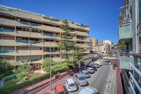 A multi-story building with balconies, a parking lot, and a clear sky. - 3 PIECES SPACIEUX CANNES CENTRE A2B067 (Cannes)