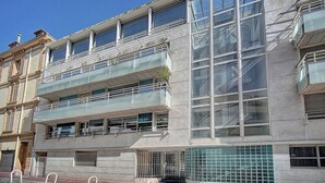 A modern building with a glass facade, multiple balconies, and a tiled entrance area. - 3 PIECES SPACIEUX CANNES CENTRE A2B067 (Cannes)