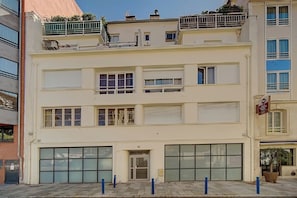 A multi-story building with large windows, a ground-level entrance, and a visible sign indicating a business establishment.