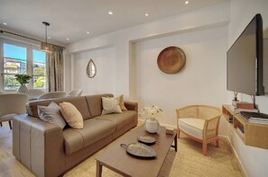 A modern living room with a sofa, coffee table, and a television.