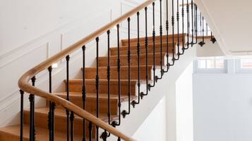 A wooden staircase with black balusters and a wooden handrail.