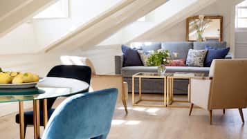A modern loft with a dining area, a sofa set, and a dining table with chairs.