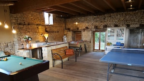 Un espacio interior acogedor con mesa de billar, mesa de futbolín y mesa de ping pong.