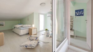 A bedroom with a bed, bedside table, and a small table with chairs. There is a window with a view of a balcony. - Fantastic Penthouse in Neos Marmaras (Sithonia)