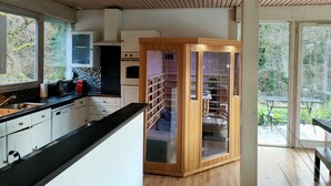 Una cocina moderna con armarios blancos, encimera negra y techo de madera.