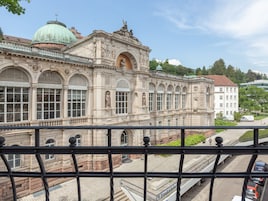 Um edifício histórico com arquitetura clássica, grandes janelas e uma cúpula.