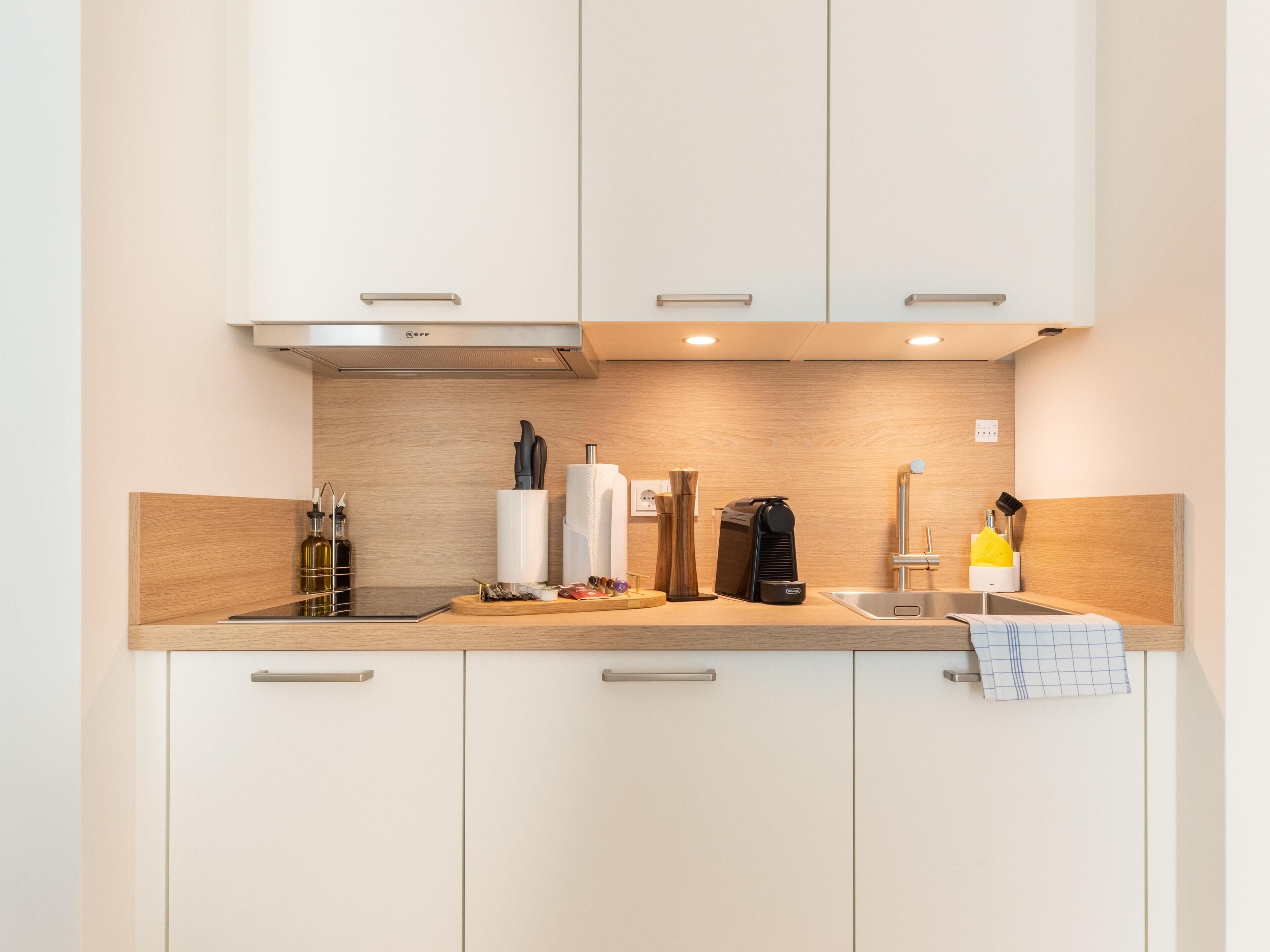 Eine moderne Küche mit weißen Schränken, einer Holz Arbeitsplatte und Edelstahlgeräten.