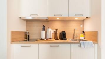 Eine moderne Küche mit weißen Schränken, einer Holz Arbeitsplatte und Edelstahlgeräten.