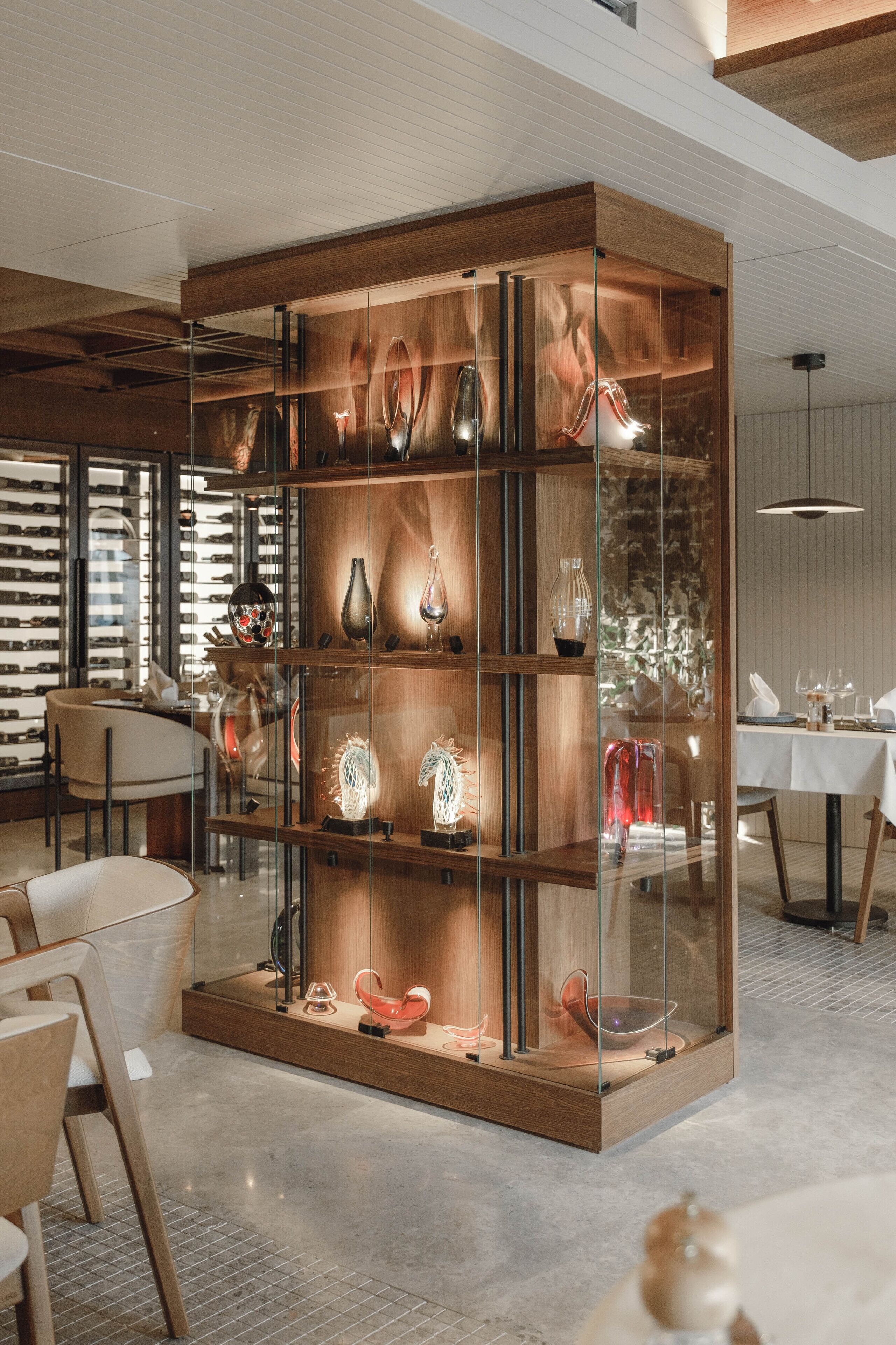 A modern interior with a central glass display case containing various decorative items.