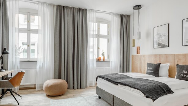 Una habitación de hotel moderna con una cama grande, un escritorio y una silla.